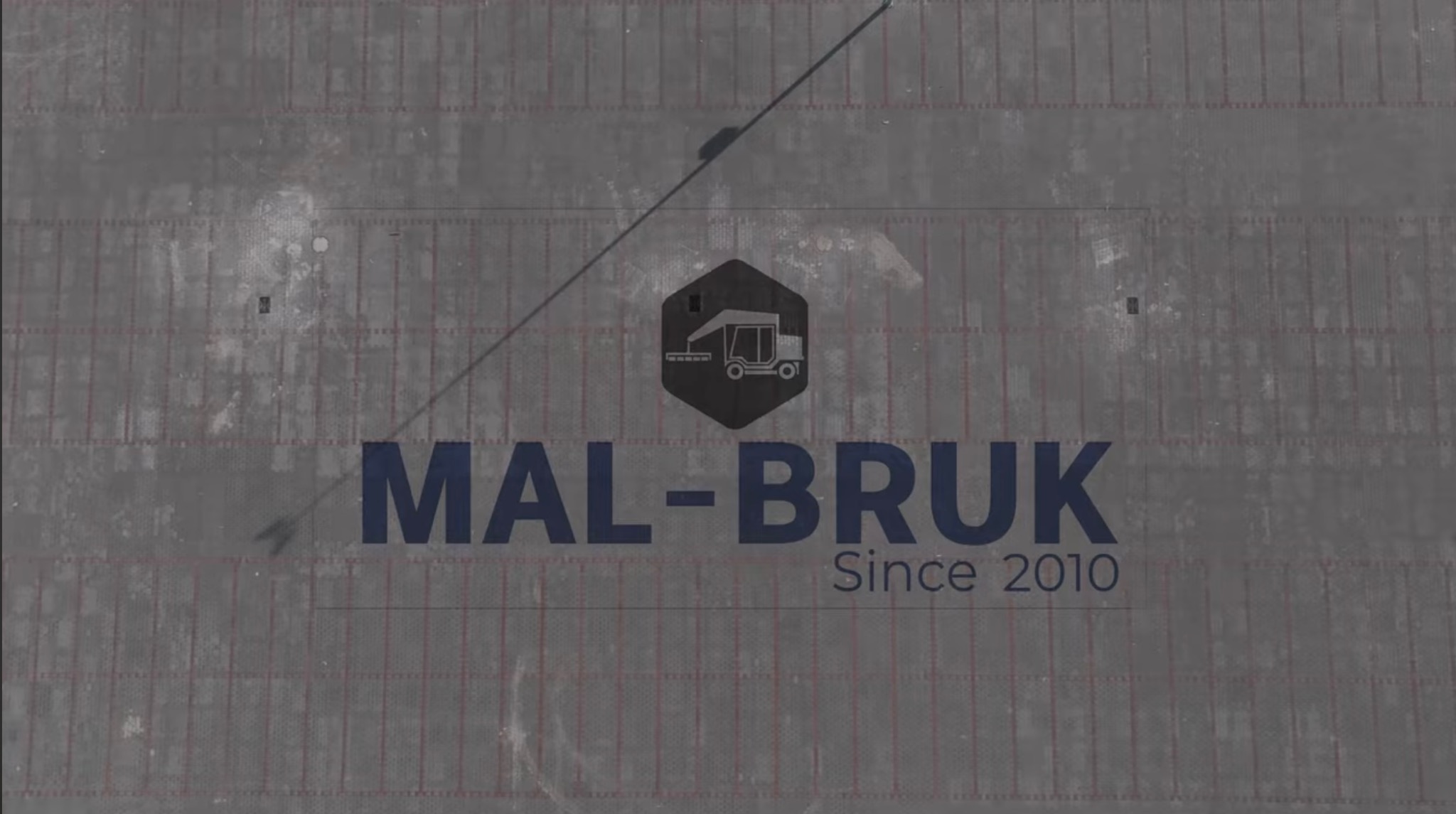 Widok z góry na ułożoną kostkę brukową z naniesionym logo firmy MAL-BRUK i napisem 'Since 2010'.
