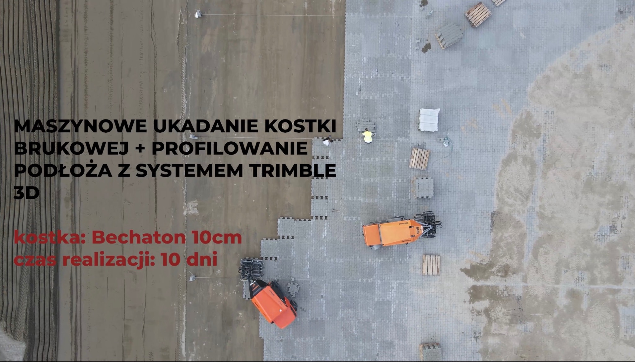 Widok z góry na plac budowy z częściowo ułożoną kostką betonową, pomarańczowe maszyny do układania kostki brukowej, palety z kostką i pracownik w żółtej koszulce, teren przygotowany pod dalsze prace.