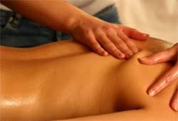 Dłonie masujące plecy pokryte olejkiem, widoczne delikatne zaczerwienienia skóry.