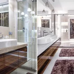 Nowoczesna łazienka z owalną umywalką nablatową, kabiną prysznicową ze szklanymi drzwiami przesuwnymi, brązowymi dywanikami i podświetlanym panelem dekoracyjnym.