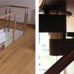 Zig zak elementy nierdzewne - Barierka schodowa z drewnianymi elementami i metalowymi linkami zabezpieczającymi, widok z góry na otwór w podłodze z drewnianą podłogą, obok fragment krętych schodów z ciemnego drewna i metalu.