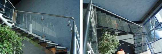 Schody wewnętrzne z drewnianymi stopniami i szklanymi balustradami ze stali nierdzewnej, oświetlone naturalnym światłem, z widoczną zielenią roślin w tle.