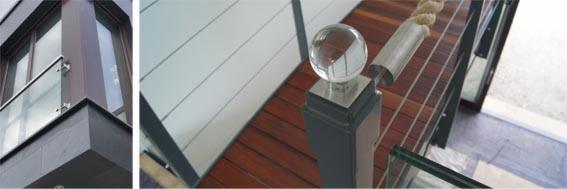 Nowoczesny balkon z szklaną balustradą i narożnym oknem, oraz drewniane schody z balustradą z elementami szklanymi i ozdobną szklaną kulą na słupku.