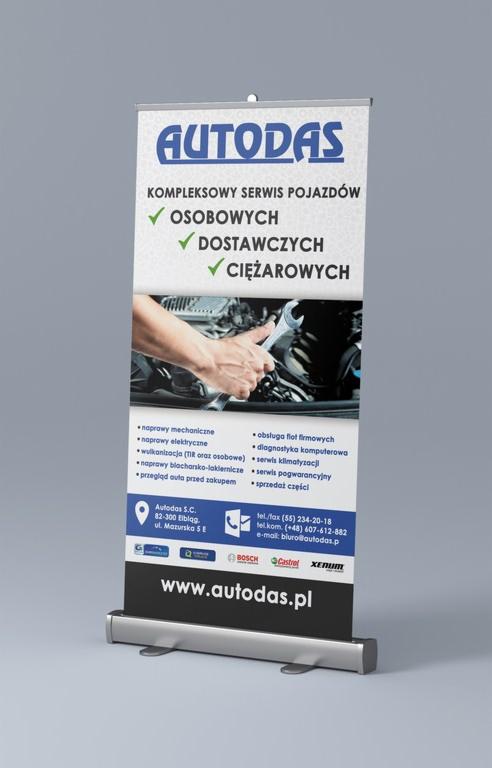 Roll-up reklamowy firmy Autodas z ofertą kompleksowego serwisu pojazdów osobowych, dostawczych i ciężarowych, prezentujący zbliżenie dłoni mechanika z kluczem nad silnikiem samochodowym.