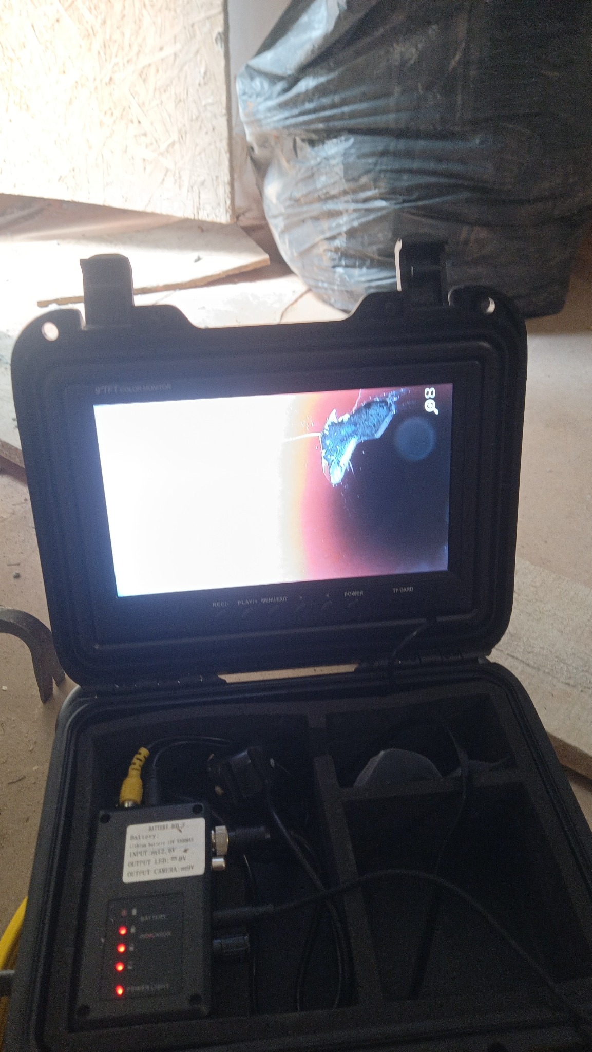 Kamera inspekcyjna w walizce z widokiem z kamery na ekranie, prawdopodobnie wewnątrz rury. Urządzenie do diagnostyki instalacji.