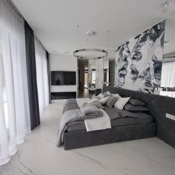 Palian Professional - Nowoczesna sypialnia z łóżkiem w odcieniach szarości, marmurową podłogą i abstrakcyjnym malowidłem na ścianie. Okno z białymi zasłonami wpuszcza naturalne światło.