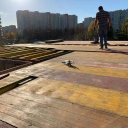 Werbex Sp z o.o. - Konstrukcja szalunkowa drewniana przygotowana pod wylanie stropu, w tle budynki mieszkalne i sylwetka pracownika.