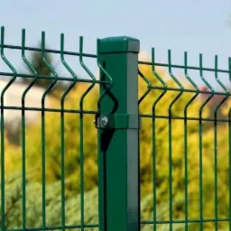 Zielony panel ogrodzeniowy z metalową siatką i słupkiem, widok z bliska na mocowanie słupka, w tle żółte krzewy.