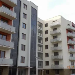 Nowoczesny budynek wielorodzinny z balkonami zabezpieczonymi balustradami ze szkła matowego i metalu, widok z dołu na elewację w stonowanej kolorystyce z elementami cegły, data 13.11.2012 w prawym...