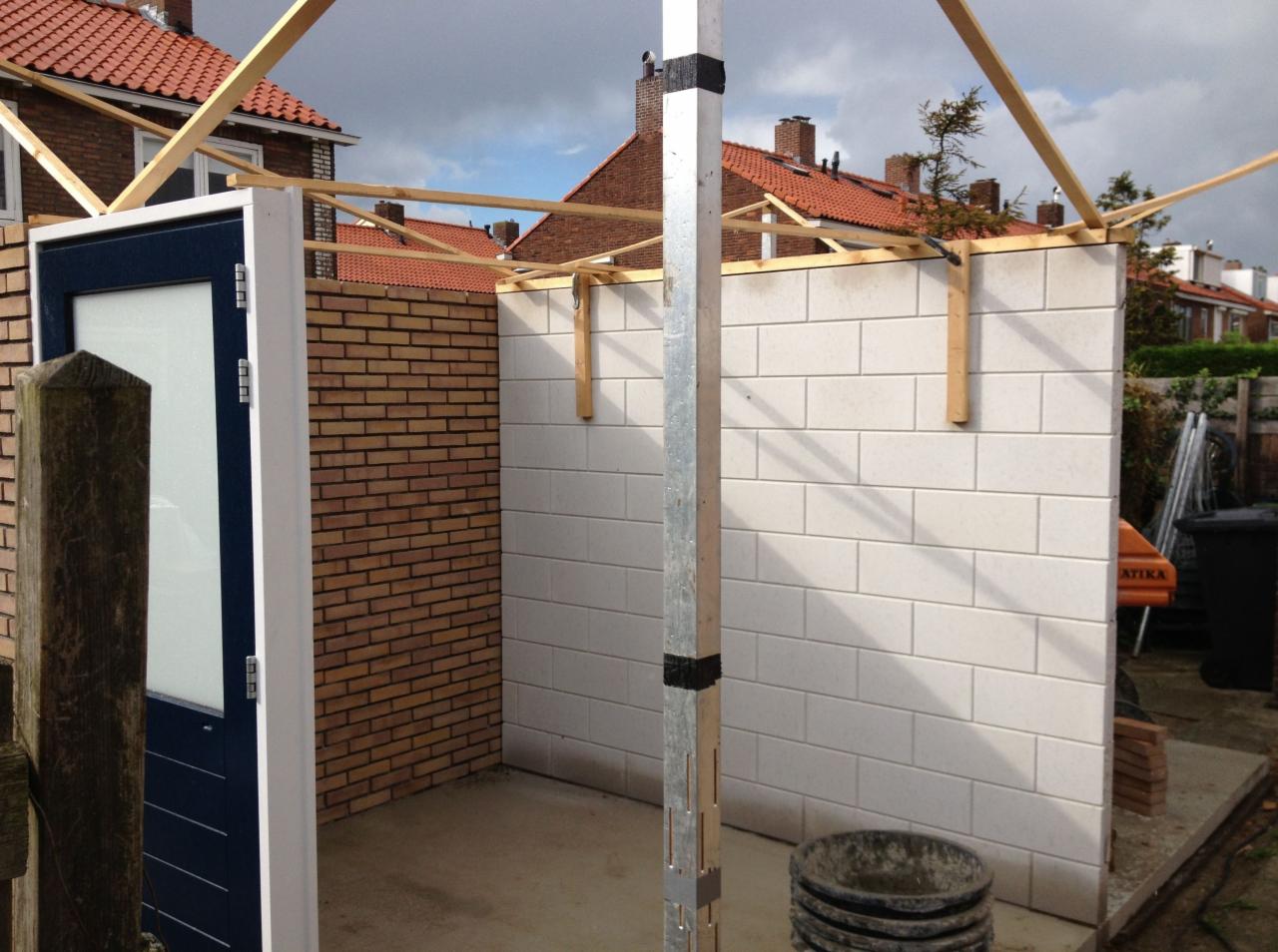 Wznoszenie ścianek działowych z cegły i bloczków betonowych, z widoczną drewnianą konstrukcją dachu, w Bytomiu, na etapie budowy.