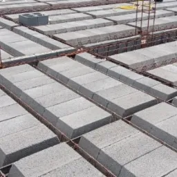 Wypełnienie stropu Teriva pustakami szalunkowymi, widoczne zbrojenie wieńca w trakcie budowy domu.