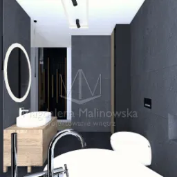 Wizualizacja łazienki z szarą kamienną ścianą, kominkiem, okrągłym lustrem z podświetleniem LED, umywalką nablatową na drewnianej szafce i wolnostojącą wanną.