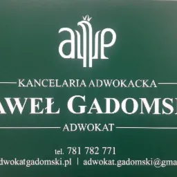 Zielona tablica informacyjna z białym napisem: Kancelaria Adwokacka Paweł Gadomski, adres strony internetowej i adres email oraz numer telefonu.