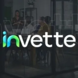 Szklane biuro z widocznym logo firmy 'invette' na szybie i zespołem pracującym w tle.