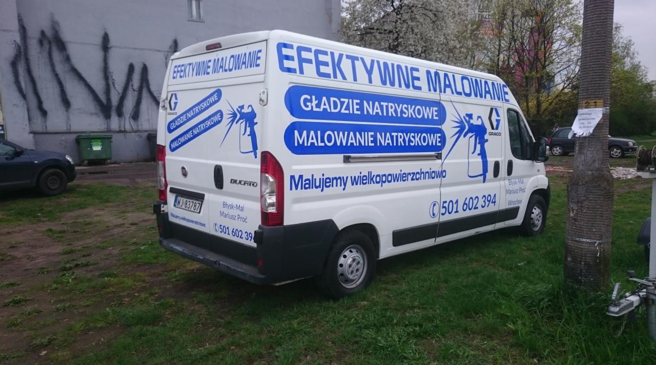 Samochód dostawczy z reklamą firmy 'Błysk-Mal' z Wrocławia, specjalizującej się w natryskowym nakładaniu gładzi i efektywnym malowaniu wielkopowierzchniowym.