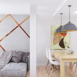 Jasne wnętrze mieszkania z szarą sofą, wzorem z miedzianych pask&oacute;w na ścianie, drewnianym stołem i trzema szarymi lampami wiszącymi.