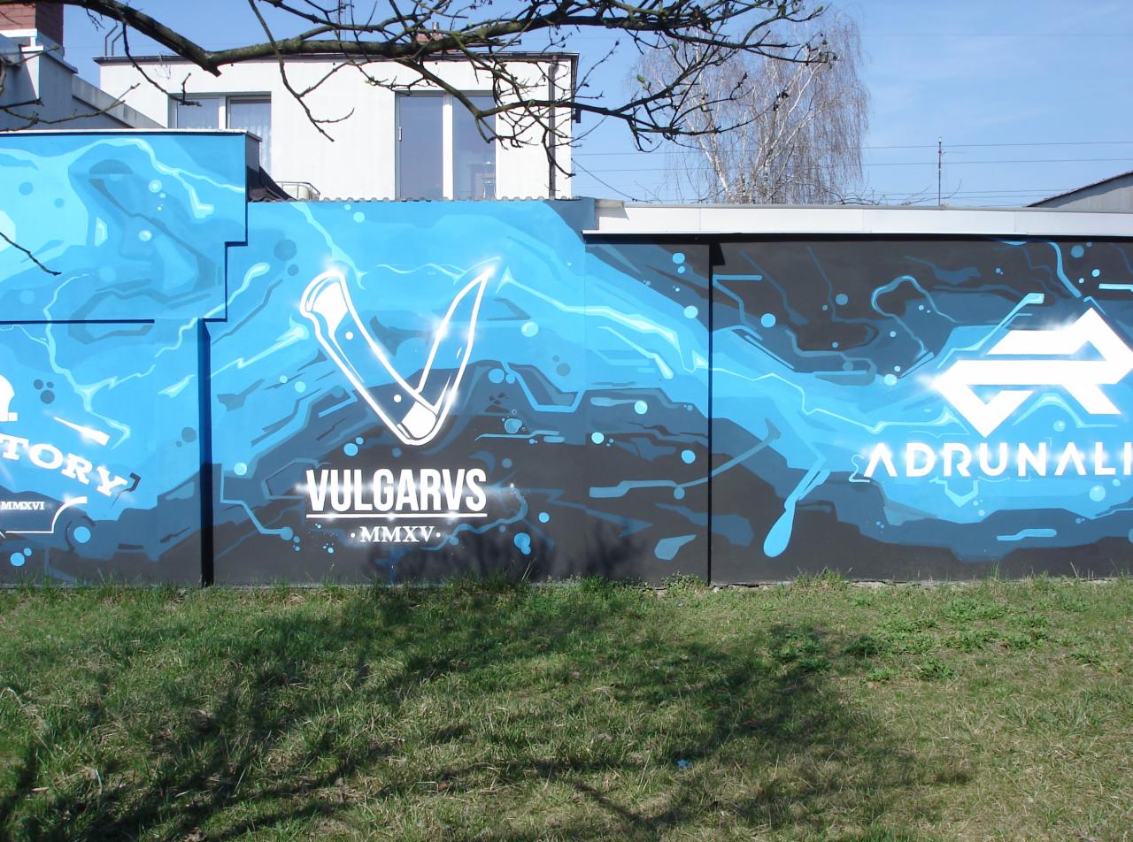 Graffiti na murze w odcieniach błękitu i czerni z futurystycznymi motywami i napisami VULGARVS i ADRUNALI.