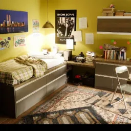 Pok&oacute;j młodzieżowy z ł&oacute;żkiem na podeście z szufladami, biurkiem, szafą i dywanem w etniczne wzory, ściany w kolorze oliwkowym zdobią plakaty i zdjęcia.