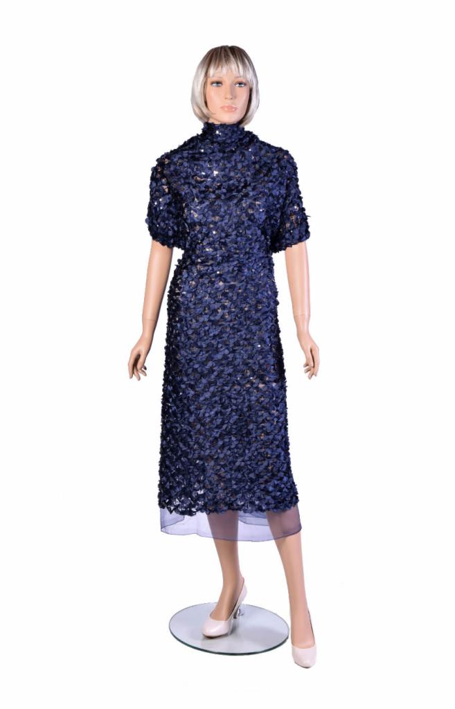 Granatowa sukienka midi z krótkimi rękawami, pokryta drobnymi, błyszczącymi aplikacjami, prezentowana na manekinie z blond peruką.