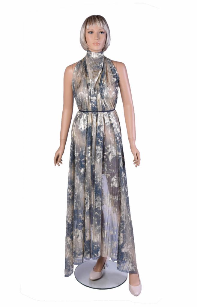 Manekin prezentuje długą, plisowaną sukienkę z abstrakcyjnym wzorem w odcieniach złota i szarości, z wysokim kołnierzem i cienkim paskiem w talii, stojący na okrągłej podstawie.
