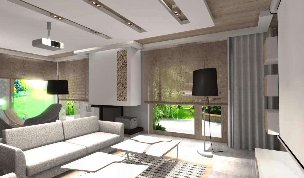 Wizualizacja salonu z szarą sofą, stolikami kawowymi, kominkiem z dekoracją z drewna, lampami podłogowymi z czarnymi abażurami, zasłonami i projektorem sufitowym.