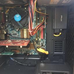 MDME Enterprise - Maciej Domagała - Wnętrze obudowy komputera stacjonarnego z widoczną płytą główną Gigabyte, kartą graficzną, procesorem Intel z radiatorem i wentylatorem, oraz dyskiem SSD PNY zamontowanym w bocznej ściance.