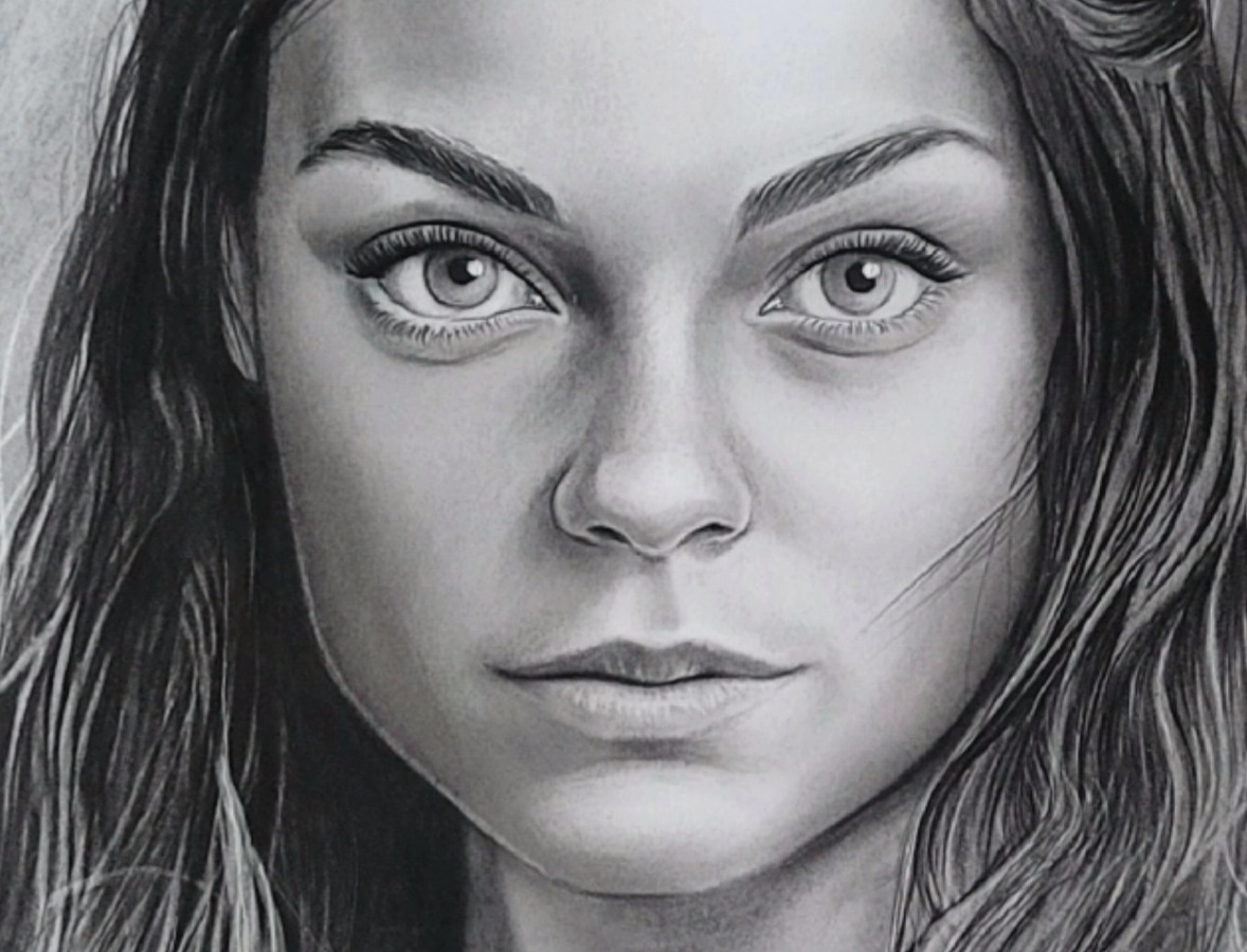 Czarno-biały portret kobiety z delikatnymi rysami twarzy, wykonany techniką ołówkową, z dużym naciskiem na realizm i detale w obrębie oczu i włosów.