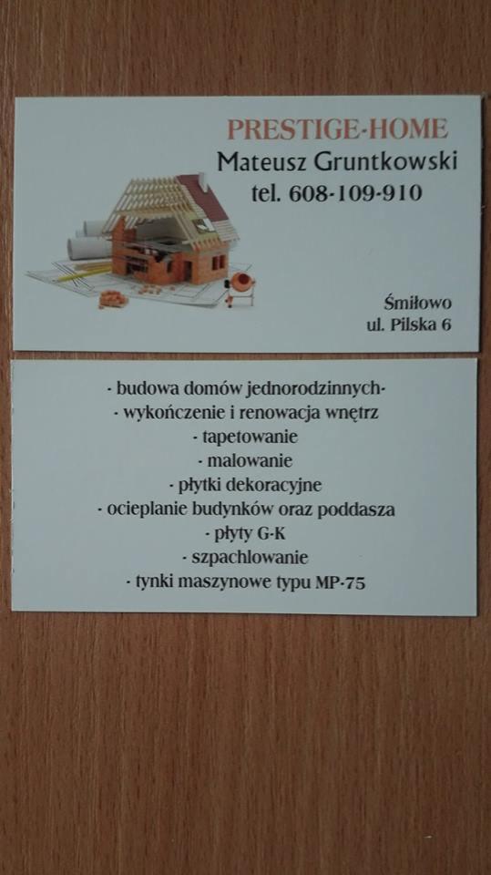 Wizytówka firmy budowlanej z Piły, prezentująca model domu w trakcie budowy na planach architektonicznych, obok betoniarka i narzędzia.