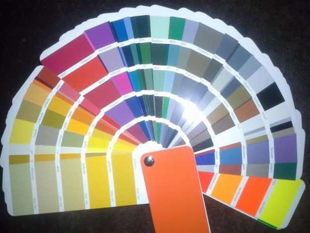 Paleta kolorów z odcieniami ułożonymi wachlarzowo na ciemnym tle, z pomarańczową kartą kolorów na pierwszym planie.