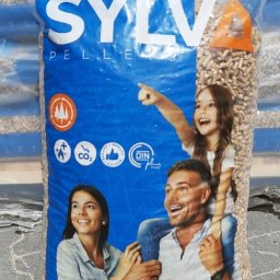 AGROLIDER - Worek z pelletem marki SYLVA z nadrukiem przedstawiającym uśmiechniętą rodzinę: kobietę, mężczyznę z córką na barana wskazującą palcem w górę.