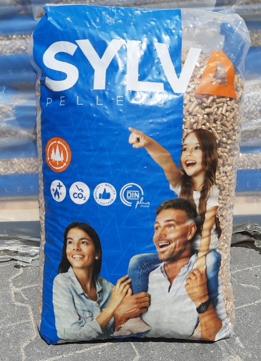 Worek z pelletem marki SYLVA z nadrukiem przedstawiającym uśmiechniętą rodzinę: kobietę, mężczyznę z córką na barana wskazującą palcem w górę.