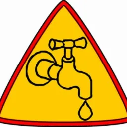 Żółty trójkątny znak ostrzegawczy z czerwoną obwódką, przedstawiający czarny symbol kranu z kroplą wody. Ostrzeżenie przed problemami hydraulicznymi.