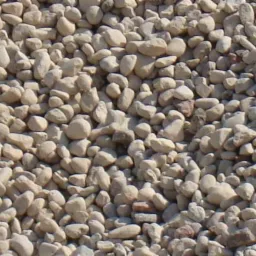 Stos małych, beżowych kamieni o zaokrąglonych kształtach, tworzących jednolitą masę, z widocznymi drobnymi różnicami w odcieniach i teksturze.