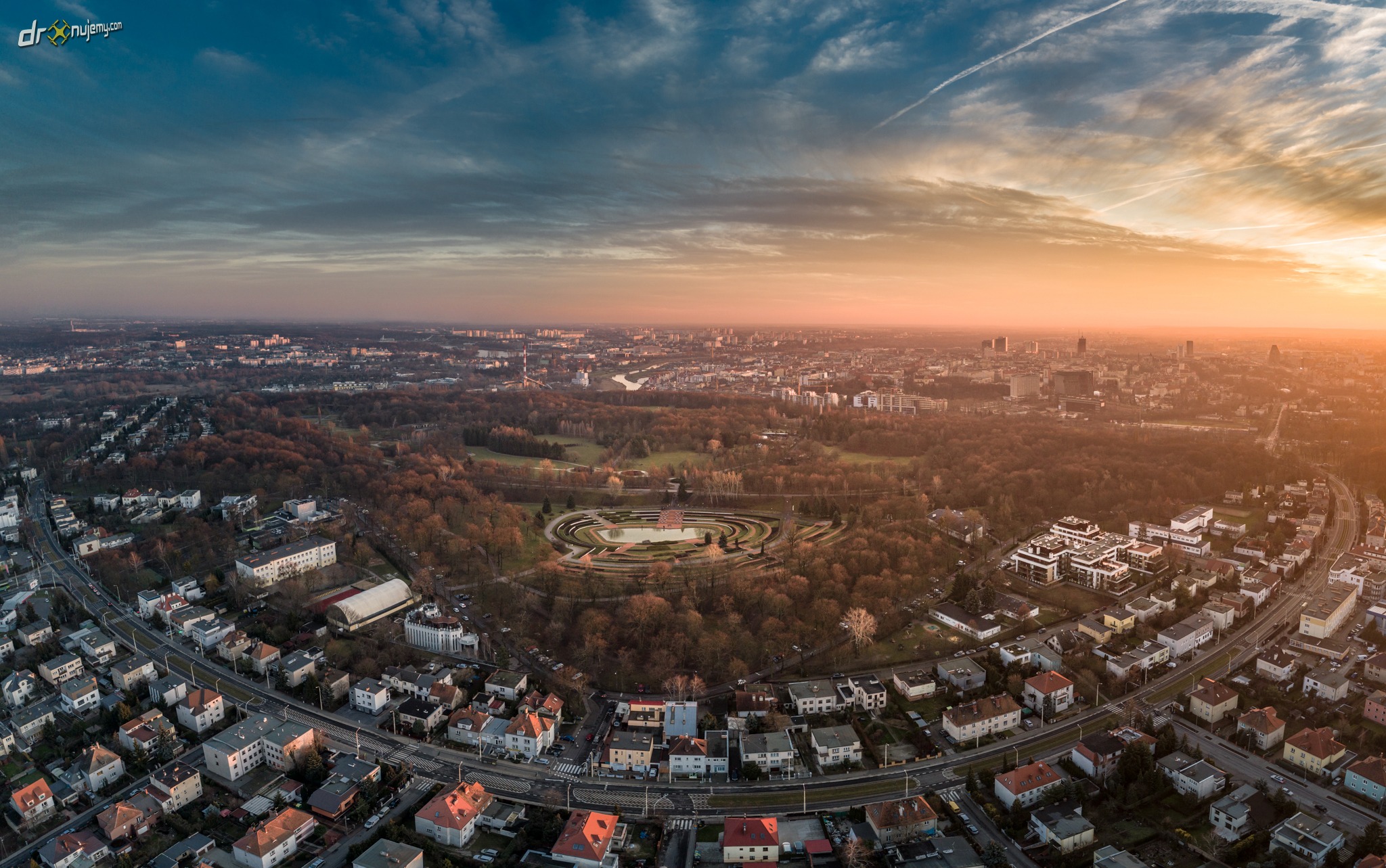 Panoramiczny widok z drona na Winogrady w Poznaniu o zachodzie słońca, z widocznym parkiem Cytadela i zabudową miejską.