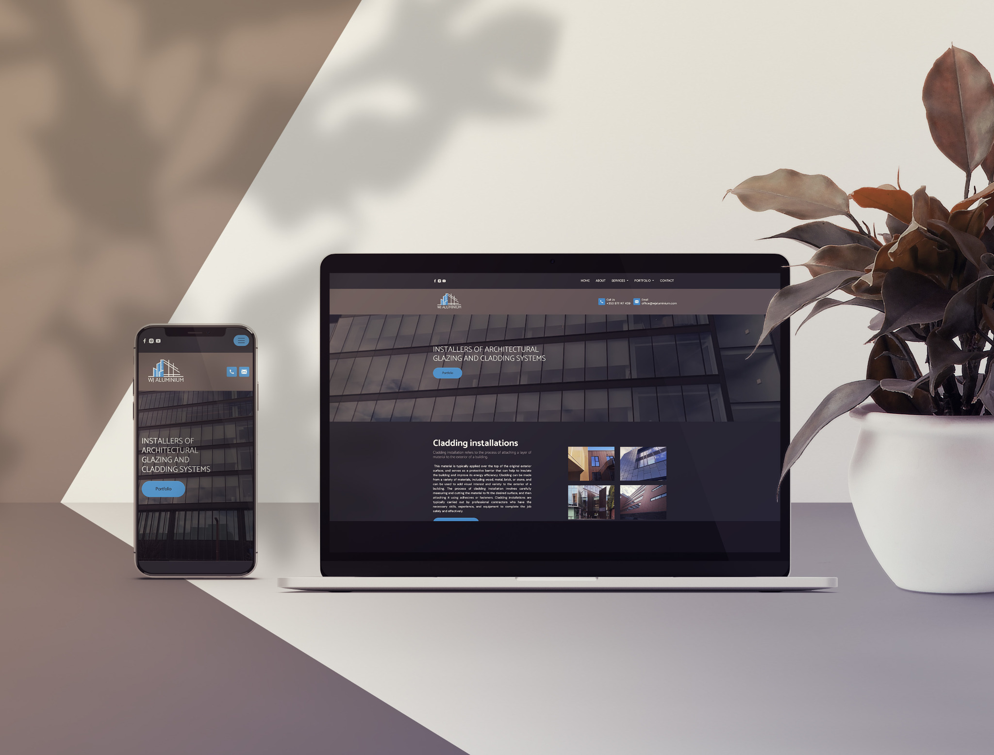 Laptop i smartfon wyświetlające stronę internetową firmy zajmującej się montażem architektonicznych systemów szklanych i okładzin. Na stronie widoczne zdjęcia realizacji. Obok doniczka z rośliną.