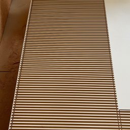 Dehha Szymon Radko - Płyta MDF z wyfrezowanymi, równoległymi rowkami, prawdopodobnie przygotowana do dalszej obróbki lub jako element dekoracyjny.