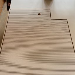 Dehha Szymon Radko - Frezarka CNC w Szczecinie obrabia płytę meblową z frezowanymi rowkami, widoczne detale mocowania i odciąg wiórów.