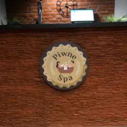 Ściana z cegły z dekoracyjnym zegarem, kranem do piwa i logo 'Piwne Spa' w kształcie kapsla.