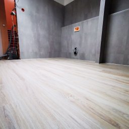 Łazienka biurowa - panele LVT na podłodze i ścianie, narożniki wykończone profilem alumininowym