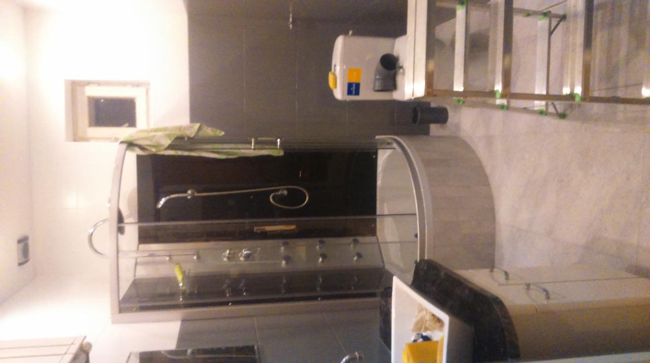 Szklana kabina prysznicowa z hydromasażem w trakcie montażu w łazience, widoczne elementy instalacji i drabina monterska.