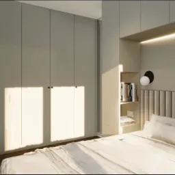 Jasna sypialnia z wbudowaną szafą i półkami na książki, oświetlona lampą ścienną. Minimalistyczny design z ciepłym oświetleniem.