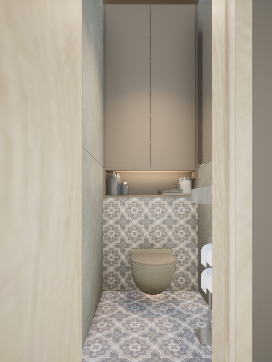 Kompaktowa, beżowa toaleta w małej łazience z wzorzystymi płytkami podłogowymi i ściennymi. Nad toaletą szafka z oświetleniem LED. Widok zza framugi drzwi.