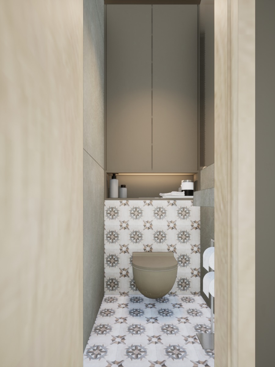 Kompaktowa łazienka z toaletą w kolorze beżowym i dekoracyjnymi płytkami w geometryczne wzory na ścianach i podłodze, zabudowa szafkowa nad toaletą.