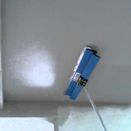 Danremo Bogumił Nosal - Aplikacja gładzi na suficie za pomocą szpachli z długim uchwytem, widoczne nierówności na powierzchni przed ostatecznym wygładzeniem.