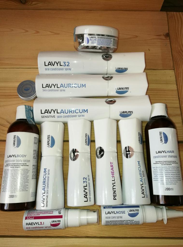 Zestaw produktów kosmetycznych marki Lavylites, w tym spraye do skóry, ust i nosa, balsam do ciała i szampon do włosów, ułożone na drewnianej powierzchni.