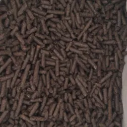 Worek wypełniony ciemnymi, cylindrycznymi granulkami, prawdopodobnie paliwem ekologicznym, widoczne drobne nierówności na powierzchni granulek.