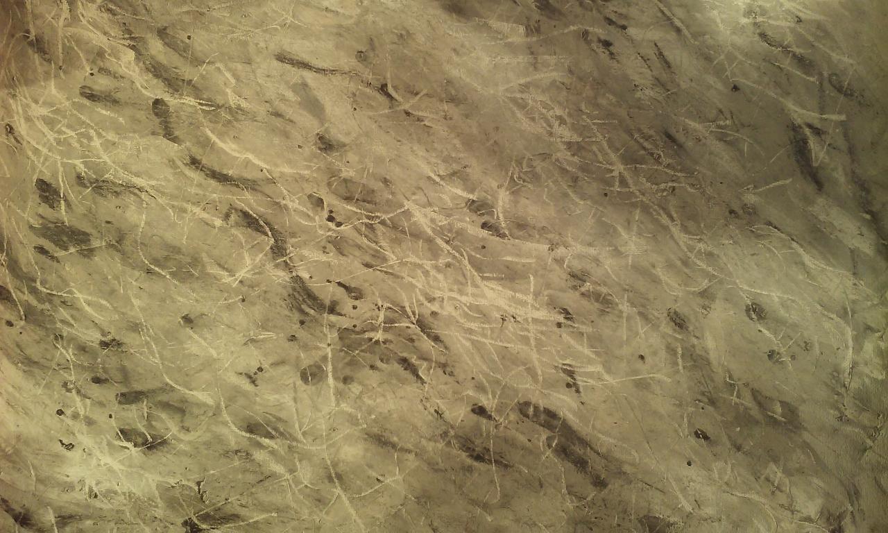 Fragment ściany z efektem dekoracyjnym imitującym popękany tynk w odcieniach beżu i szarości, z widoczną fakturą i drobnymi zabrudzeniami.