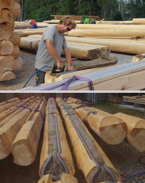 Pracownik w okularach docina wełnę mineralną do izolacji drewnianych bali za pomocą narzędzia pneumatycznego; widoczne bale z wyżłobieniami wypełnionymi wełną i szarym uszczelniaczem.