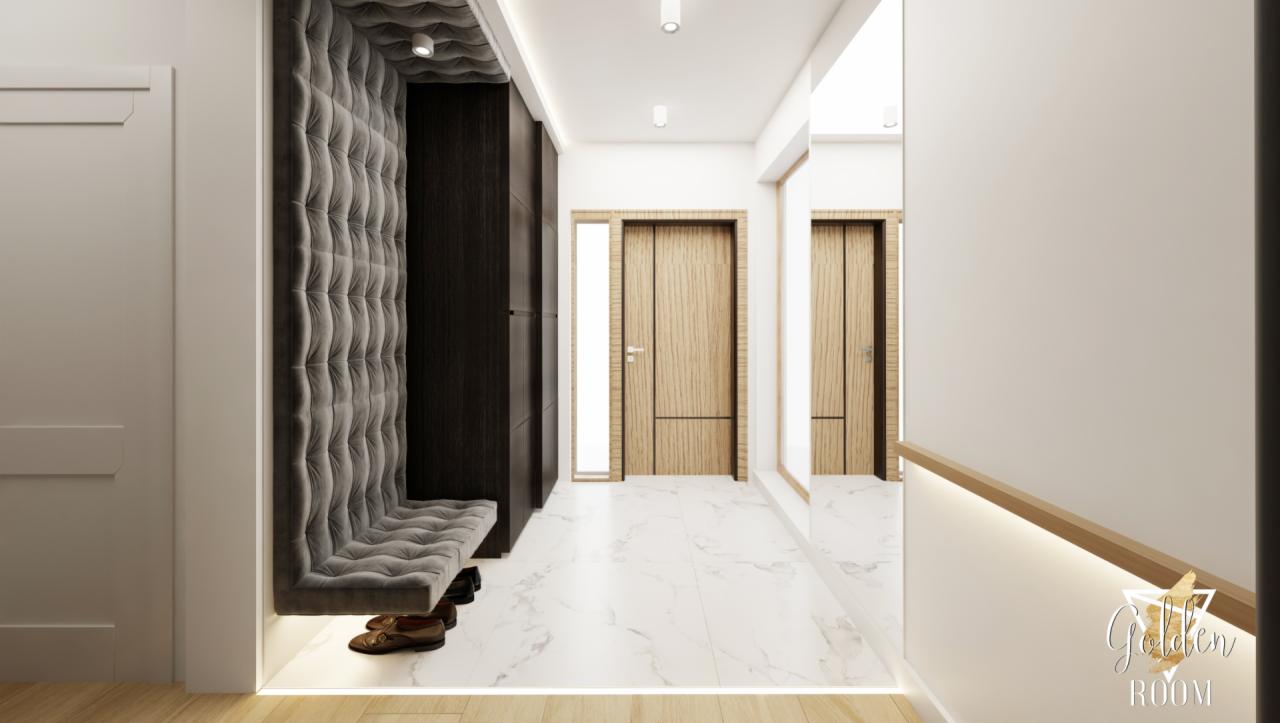 Nowoczesny przedpokój z tapicerowanym siedziskiem ściennym w szarym kolorze, podświetlanym od dołu, oraz ciemną szafą w zabudowie; na marmurowej podłodze leżą brązowe buty.