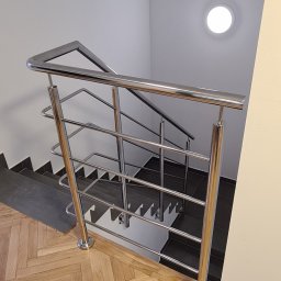 On Yacht - Klatka schodowa z drewnianą podłogą w jodełkę i nowoczesną balustradą ze stali nierdzewnej z poziomymi poprzeczkami, widok z góry.